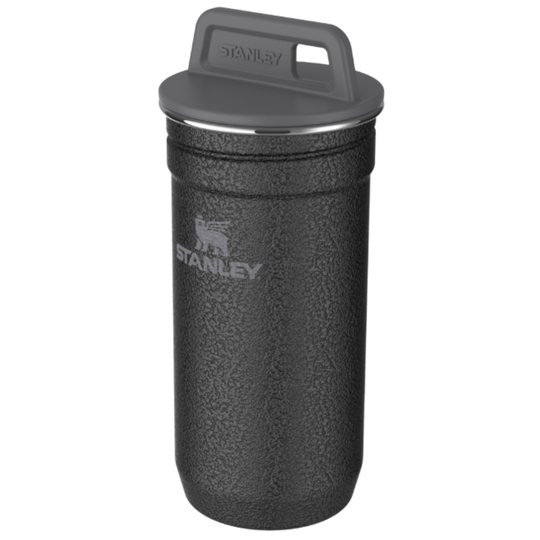 A Stanley insulated travel tumbler in textured black with a dark gray lid and carry handle, shown on a plain white background.