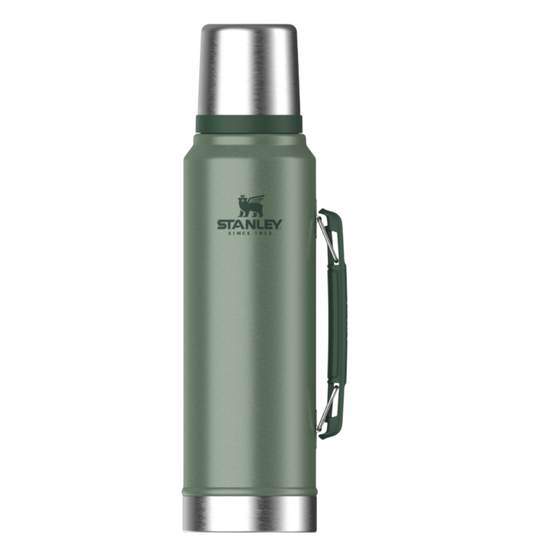 A green Stanley vacuum-insulated water bottle with a silver stainless steel cap and base, featuring a dark green carrying loop on the side.