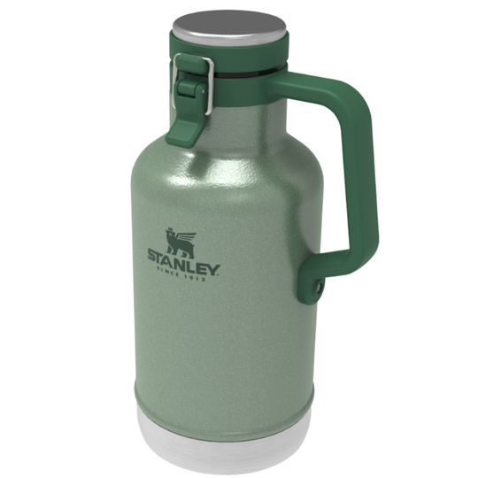 A Stanley growler bottle in a metallic sage green finish, featuring a dark green handle, a silver lid, and the Stanley logo printed on the front, set against a plain white background.