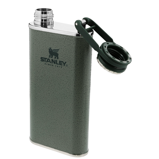 A dark green textured Stanley flask with a silver metal cap and a dark green carrying loop, shown on a plain white background.