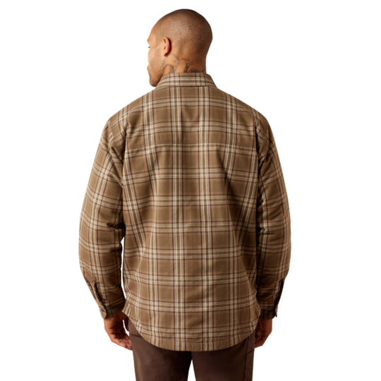 A man viewed from the back wearing a brown and beige plaid button-down shirt, paired with dark brown pants, against a solid white background.