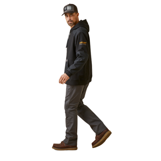 Man wearing a black hoodie with a logo, gray pants, and brown boots on a white background