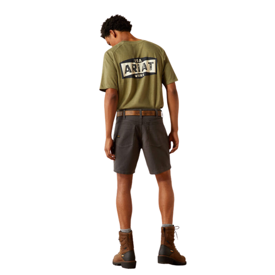 A man shown from the back wearing an olive green t-shirt with a large 'Ariat Wear' logo on the back, paired with dark gray shorts and brown boots, against a plain white background.