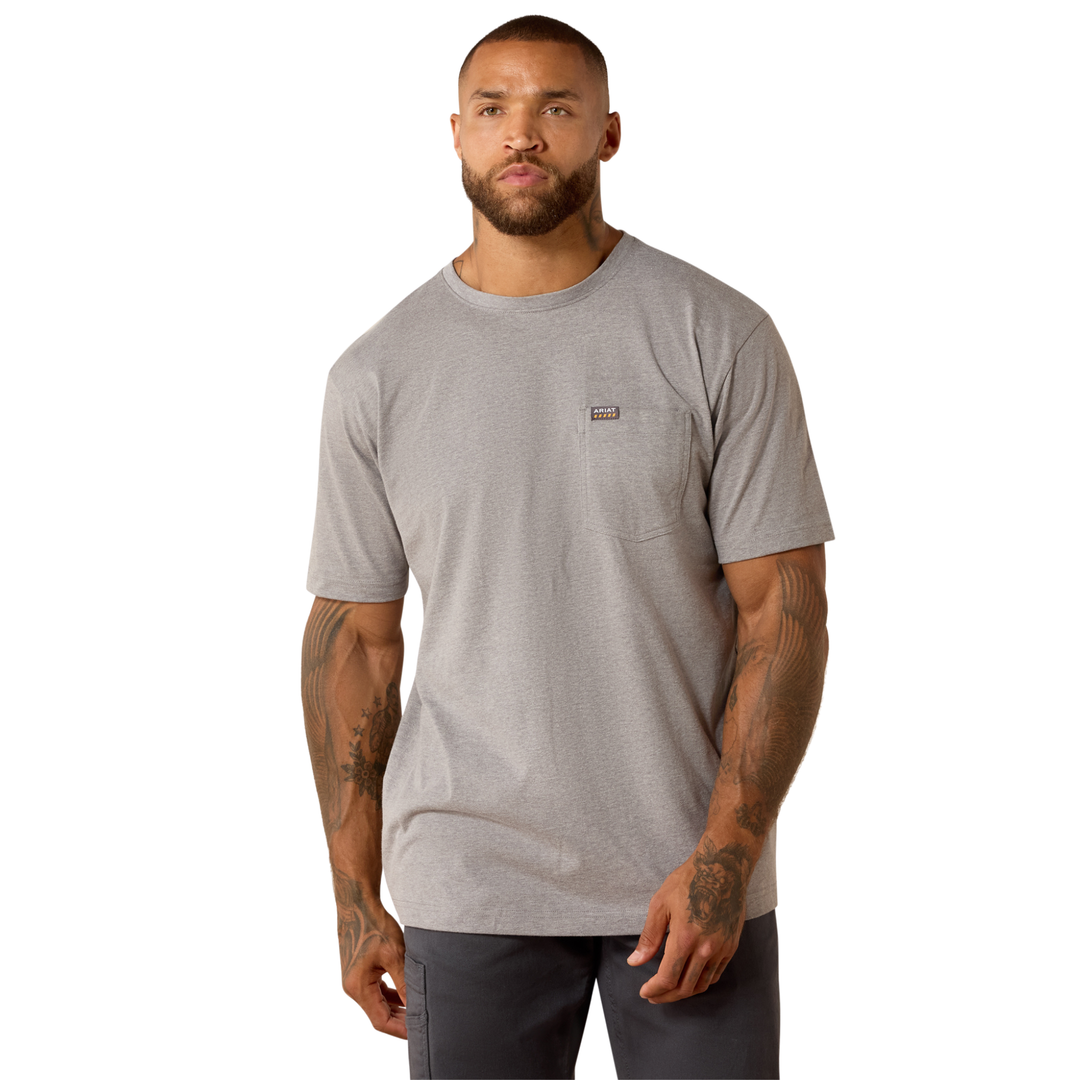 A man wearing a light gray heather crewneck pocket t-shirt with a small Patagonia logo on the chest, paired with dark gray pants, photographed against a solid white background.