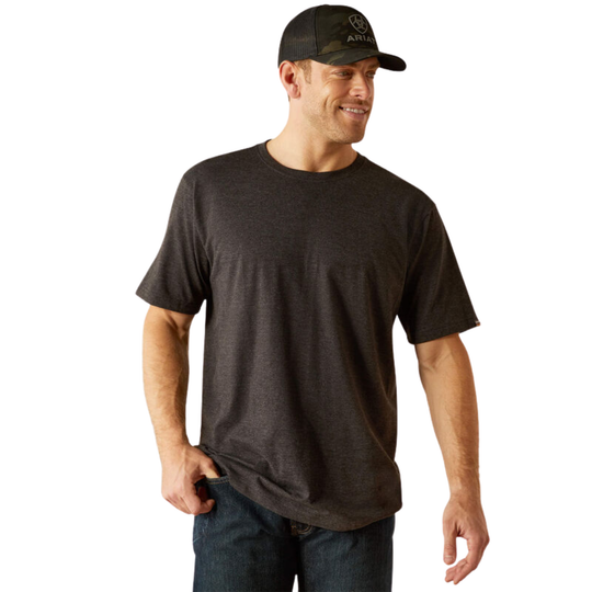A man wearing a dark charcoal gray short-sleeve crewneck t-shirt and a black baseball cap, standing against a plain white background.
