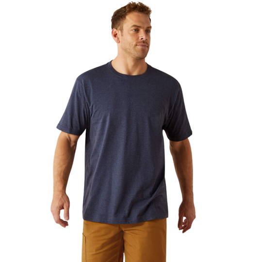 A man wearing a heather navy blue crewneck t-shirt and tan pants, standing against a plain white background.