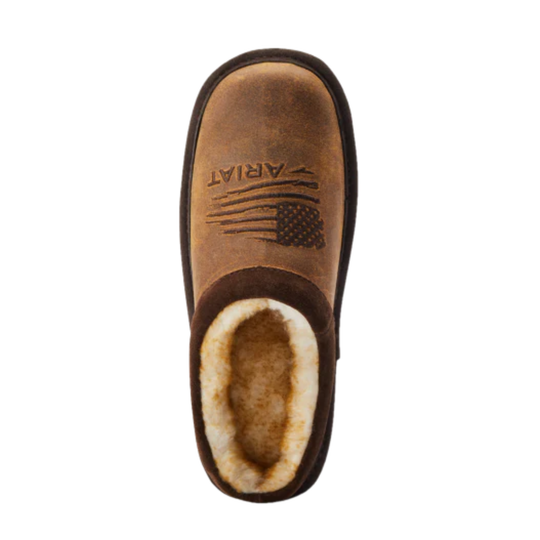 A single brown slip-on slouch boot with a soft cream shearling lining, featuring an embossed American flag design and the brand name 'ARIAT' on the side, shown against a plain white background.