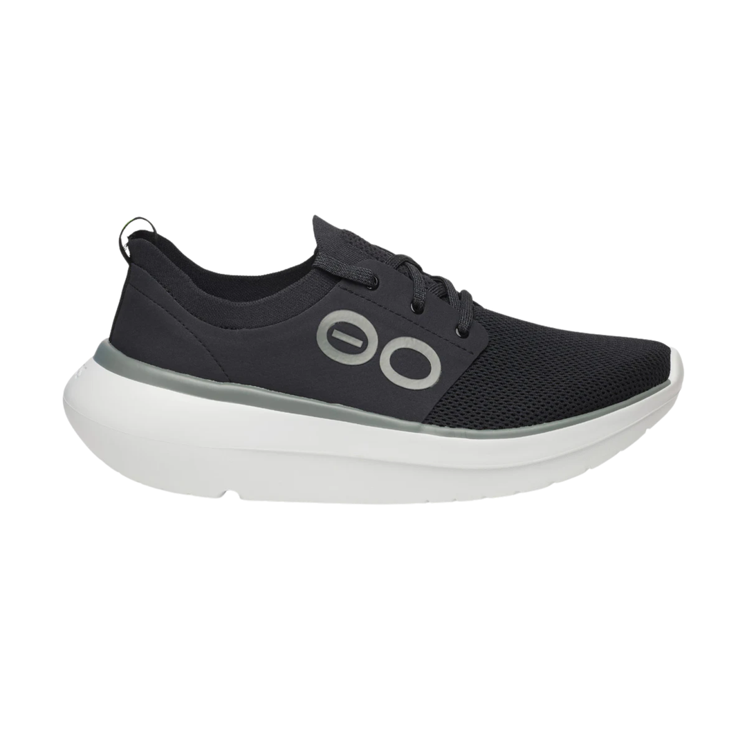A black mesh athletic sneaker with a thick white sole and a gray circular logo on the side, shown against a plain white background.