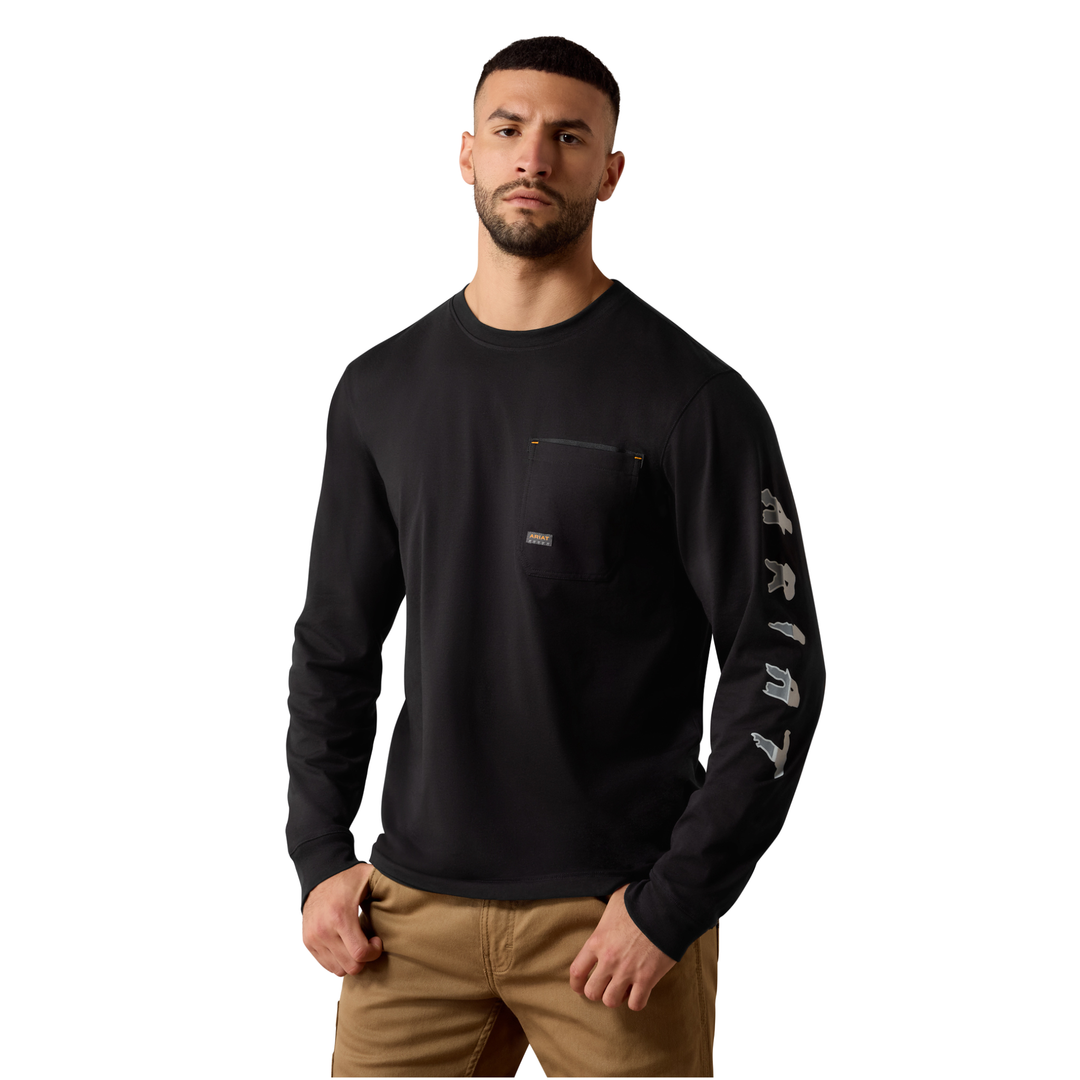 A man wearing a black long-sleeve crewneck shirt with a chest pocket and white vertical 'E-TRAIL' branding on the right sleeve, paired with tan pants, against a plain white background.
