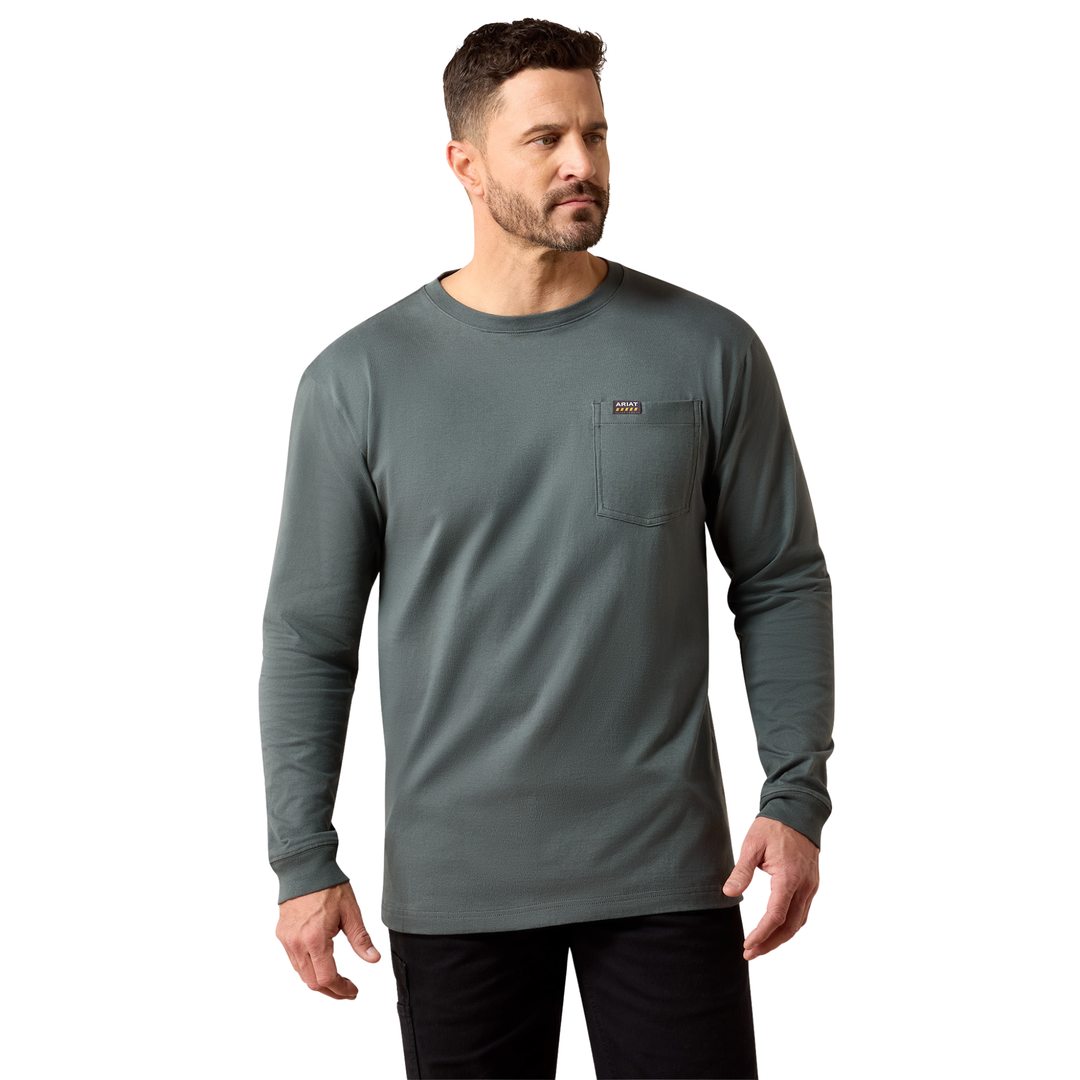 A man wearing a dark gray long-sleeve crewneck shirt with a chest pocket, paired with black pants, photographed against a solid white background.