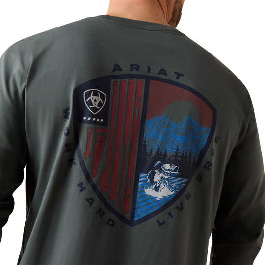 A man wearing a dark gray long-sleeve shirt, viewed from the back. The shirt features a large graphic print on the back with the brand name 'ARIAT' and the text 'WORK HARD LIVE FREE' surrounding a shield design with red, blue, and black elements.
