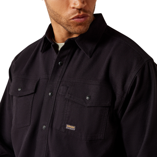 Man wearing a black shirt with a brand logo on a white background