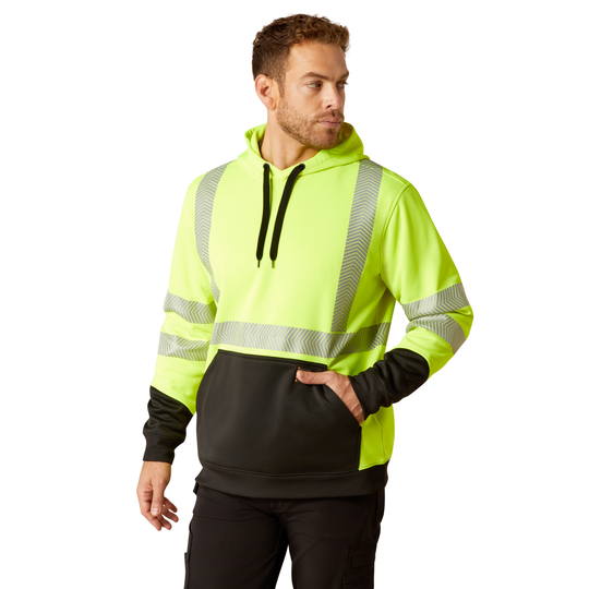 A man wearing a high-visibility neon yellow-green pullover hoodie with reflective silver stripes, a black front kangaroo pocket, and black drawstrings, paired with black pants, against a plain white background.