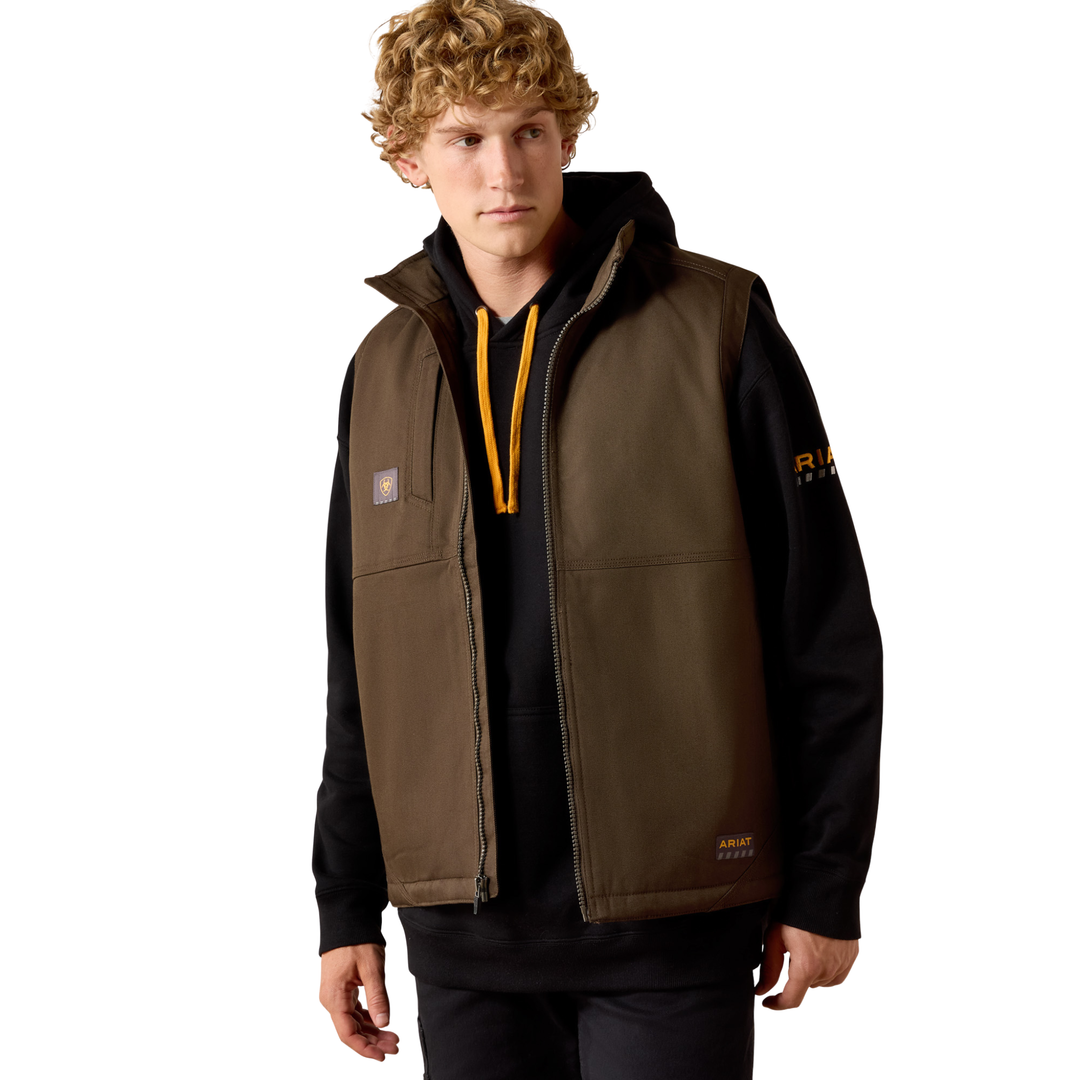 Man wearing a brown and black jacket with visible branding on a beige background