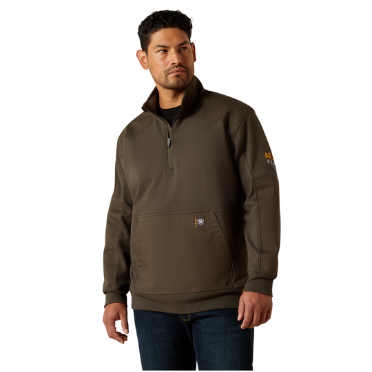 A man wearing a dark brown quarter-zip pullover sweatshirt with a small logo on the chest and sleeve, paired with dark blue jeans, against a plain white background.