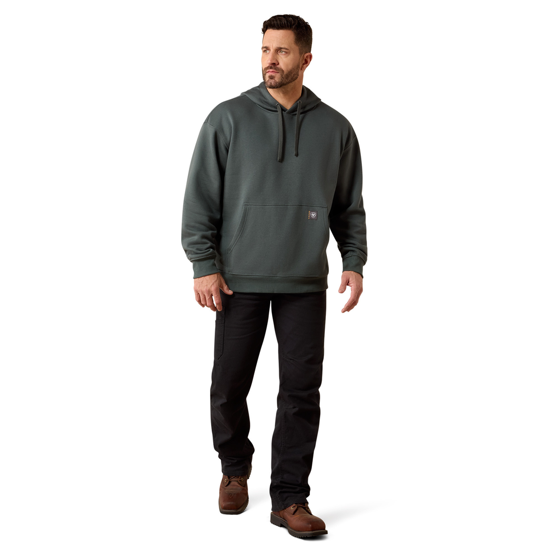 A man wearing a dark gray hooded sweatshirt, black pants, and brown shoes, standing against a plain white background.