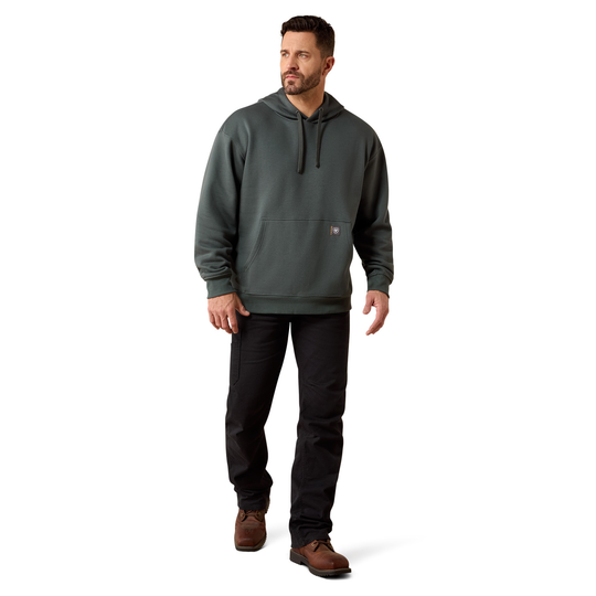A man wearing a dark gray hooded sweatshirt, black pants, and brown shoes, standing against a plain white background.