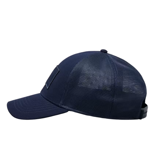 A navy blue trucker-style baseball cap with a curved brim, structured front panel, and mesh back panels, shown from a side profile view on a white background.
