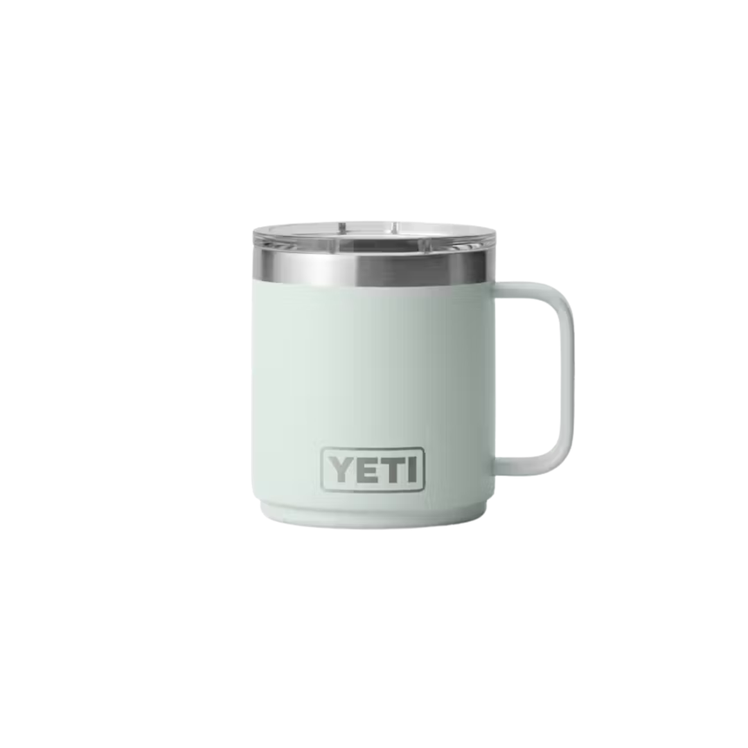 A YETI insulated mug in a pale mint green color, featuring a stainless steel rim and a white handle, shown against a plain white background.