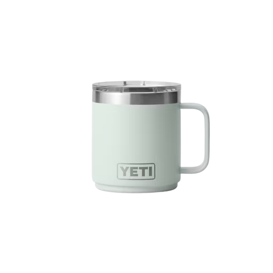 A YETI insulated mug in a pale mint green color, featuring a stainless steel rim and a white handle, shown against a plain white background.