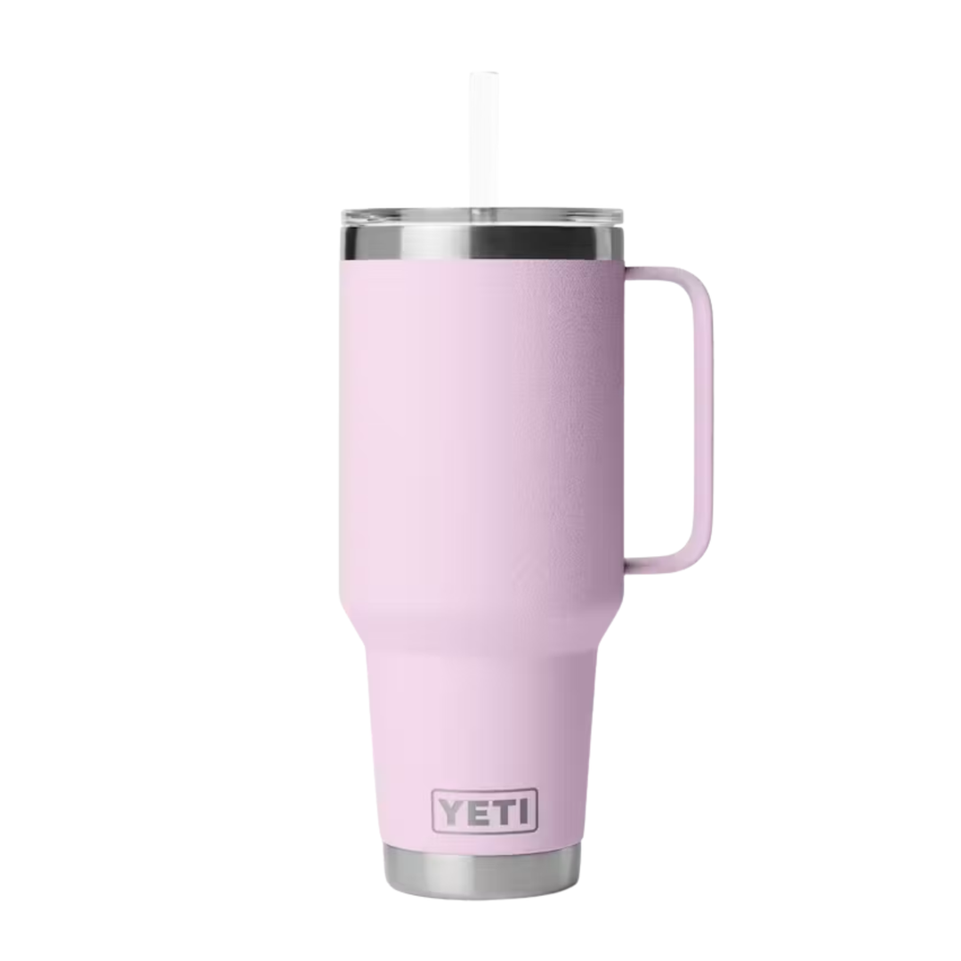 A light pink YETI insulated travel tumbler with a handle, a clear lid, and a straw, shown against a plain white background.