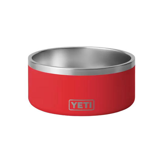 A red YETI pet bowl with a brushed stainless steel interior and rim, featuring the YETI logo on the front, set against a plain white background.