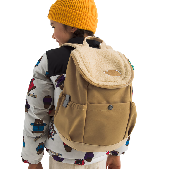 Person wearing a beige backpack and yellow beanie on a white background