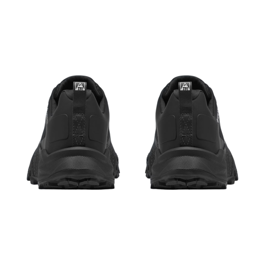 A pair of black trail running shoes shown from the rear, featuring a chunky black sole and a small white logo on the heel collar, set against a plain white background.