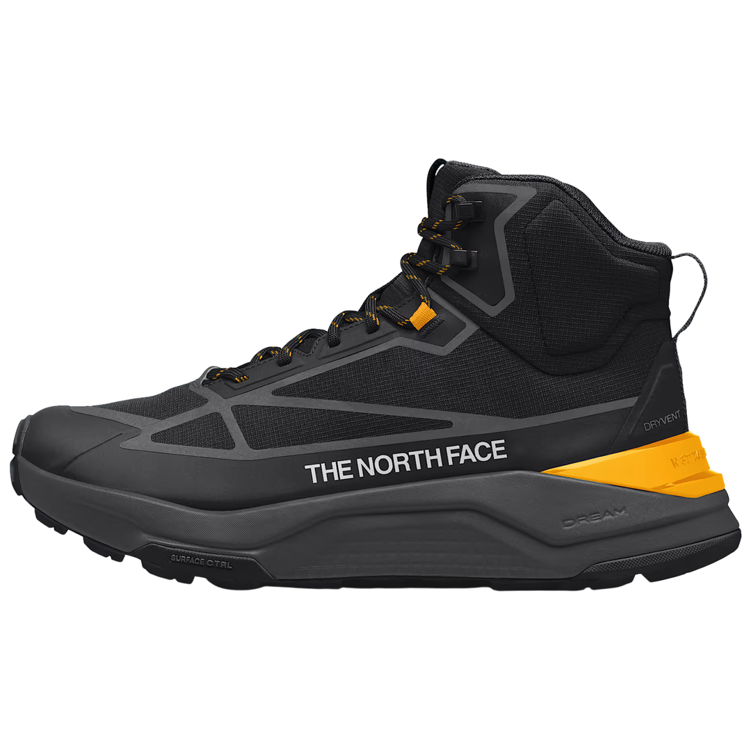A black and dark gray mid-top hiking boot by The North Face, featuring a bright yellow accent on the heel and a white brand logo on the side, shown against a plain white background.