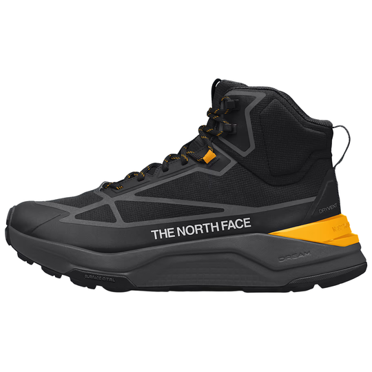 A black and dark gray mid-top hiking boot by The North Face, featuring a bright yellow accent on the heel and a white brand logo on the side, shown against a plain white background.