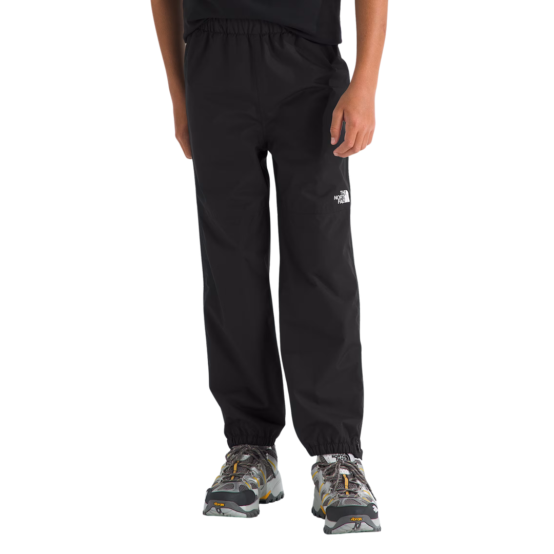 Black jogger pants with an elastic waistband and cuffs, featuring a small white The North Face logo on the left thigh, shown on a model wearing camouflage sneakers against a white background.