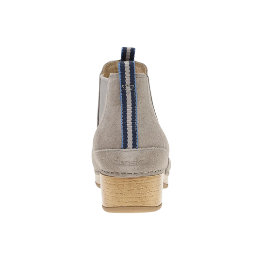A single light gray suede Chelsea-style ankle boot shown from the back, featuring a stacked natural wood heel and a vertical navy and white striped pull tab.
