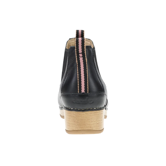 A black leather ankle boot shown from the back, featuring a light wood block heel and a pink and black striped pull tab.