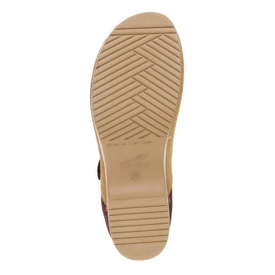 The tan outsole of a shoe, showing a herringbone tread pattern and embossed branding, photographed from a top-down view on a white background.
