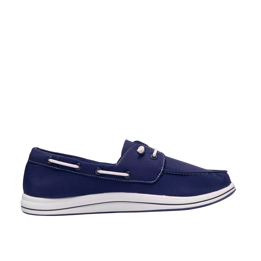 A navy blue boat shoe with white accents, including a white sole and white eyelet details, shown in a side profile view against a plain white background.