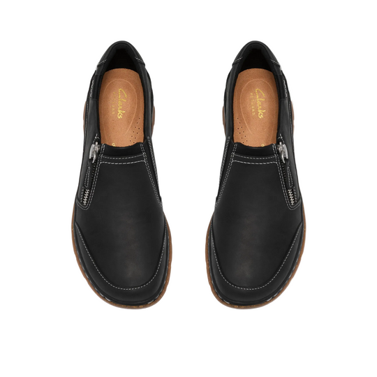 A pair of black leather slip-on shoes with silver zipper details and white contrast stitching, shown from a top-down view on a white background.