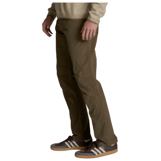 A person wearing olive brown pants, a beige sweater, and brown sneakers with white stripes, shown from the waist down against a plain white background.