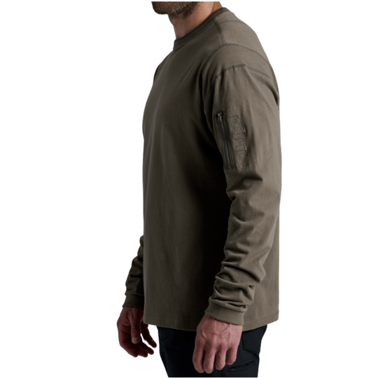 A man wearing a long-sleeve olive green technical shirt, shown from a side profile against a plain white background.