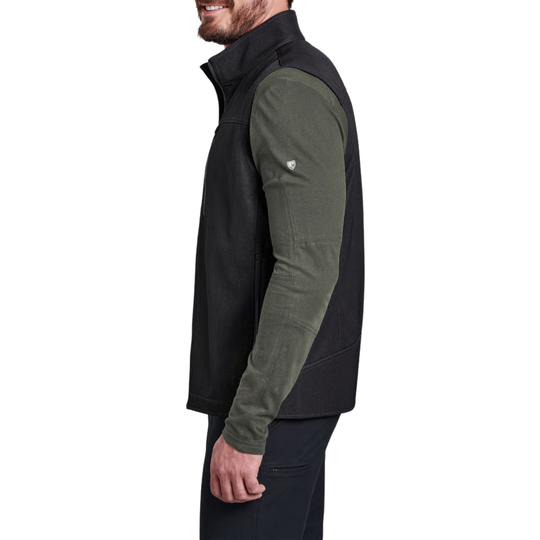 A man wearing a black and olive green quarter-zip fleece vest, shown in profile against a plain white background.
