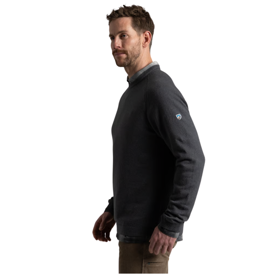 A man wearing a dark charcoal gray pullover sweater, shown from a side profile against a solid white background.