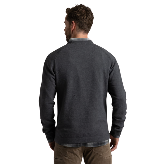 A man viewed from the back wearing a dark charcoal gray long-sleeve knit sweater over a collared shirt and brown pants, against a plain white background.