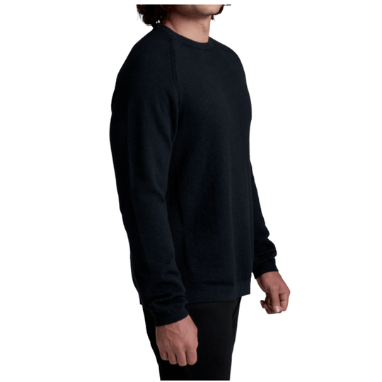 A man wearing a dark navy crewneck sweater, shown from a side profile view against a plain white background.