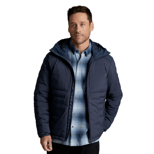 A man wearing a navy blue hooded puffer jacket over a blue and gray plaid button-down shirt, photographed against a solid white background.