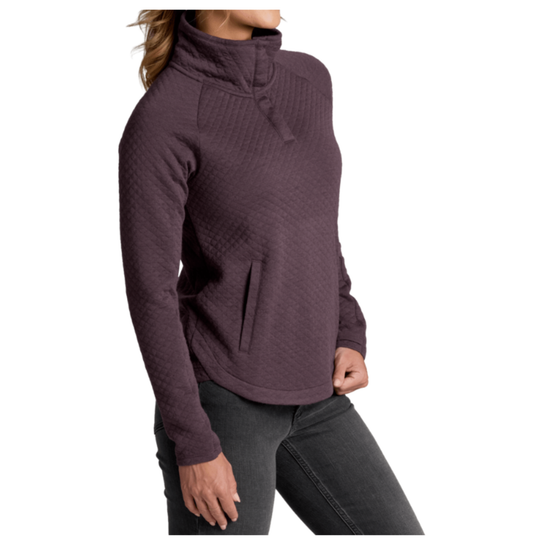 A woman wearing a dark plum purple quilted long-sleeve quarter-zip pullover sweater with dark gray jeans, shown from the side against a plain white background.