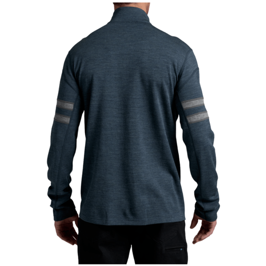 A man viewed from the back wearing a dark slate blue heathered quarter-zip pullover with two horizontal gray reflective stripes on both sleeves, paired with black pants, against a plain white background.
