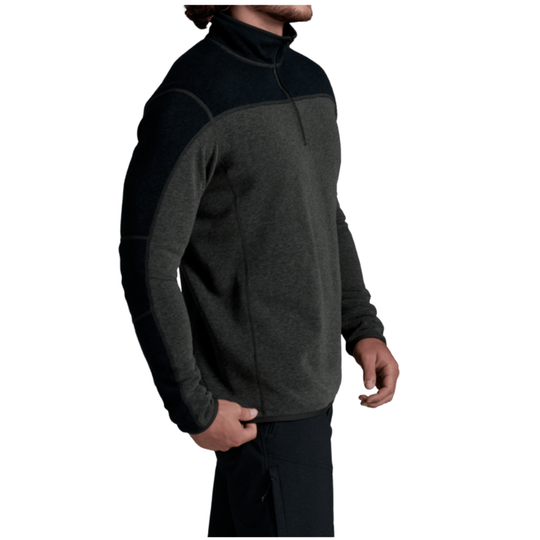 A man wearing a dark gray and black quarter-zip fleece pullover, shown from a side profile against a plain white background.