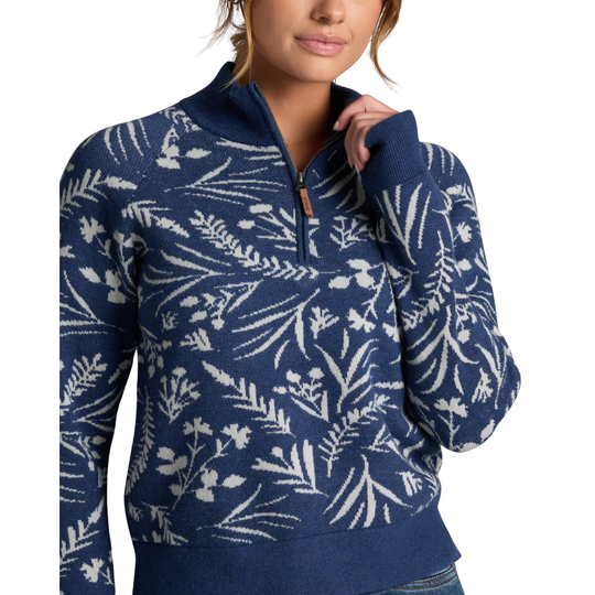 A woman wearing a navy blue quarter-zip sweater with a white botanical leaf pattern, shown from the chest up against a plain white background.