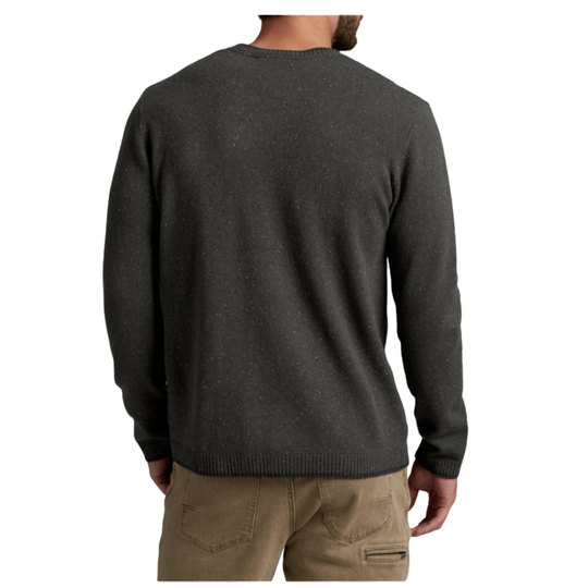 A man viewed from the back wearing a dark charcoal gray knit sweater and tan pants, set against a plain white background.