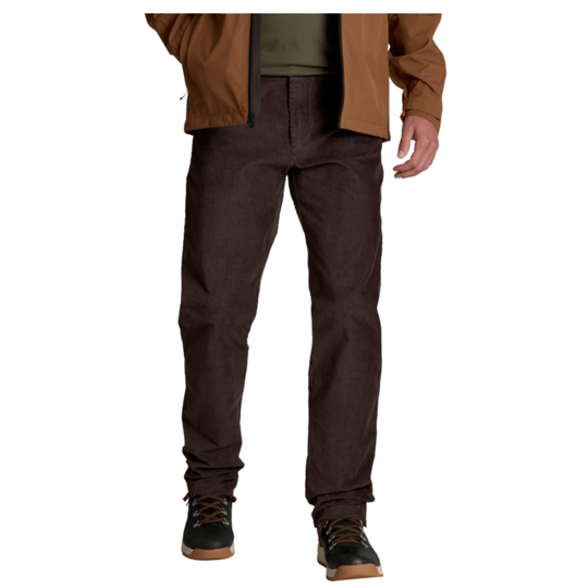 A person wearing dark brown work pants, a brown jacket, and black work boots, shown from the waist down against a plain white background.