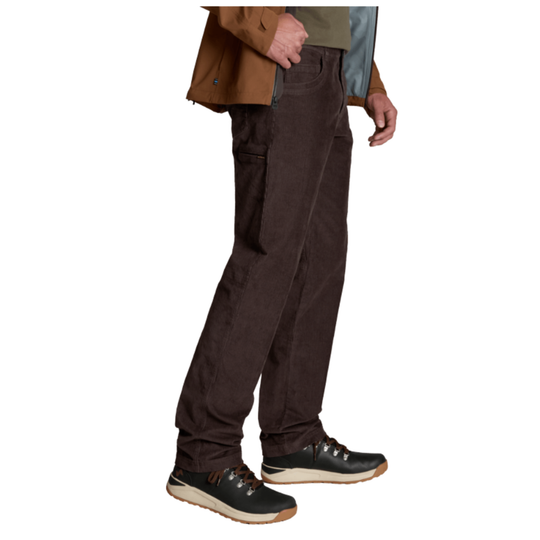 A person wearing dark brown corduroy pants, a brown jacket, and black sneakers, shown from the waist down against a plain white background.